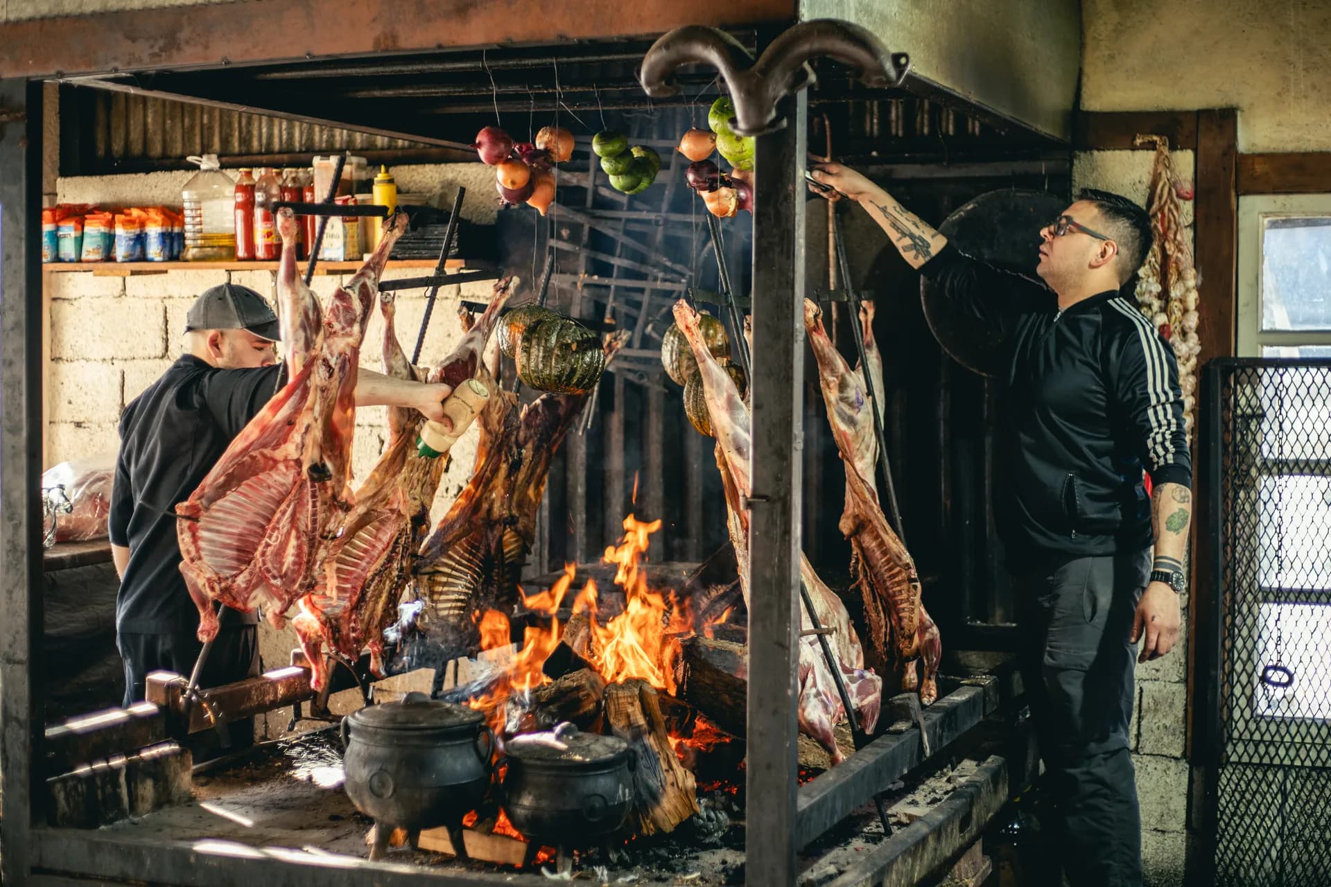 A cozinha de fogo completa, com o assador trabalhando entre as cruzes