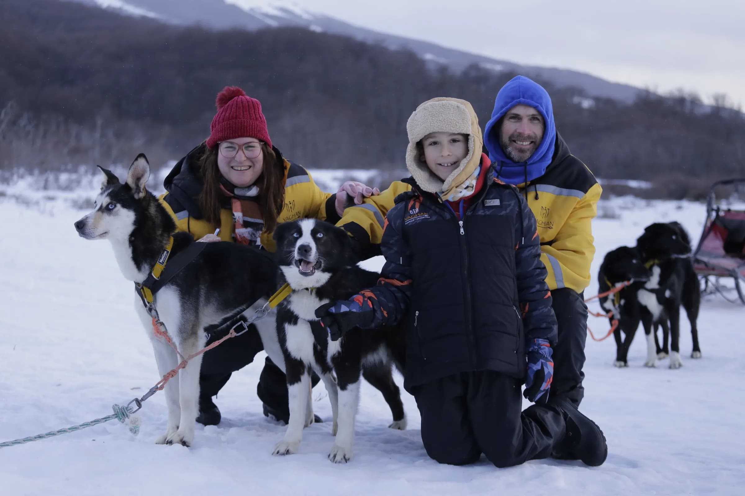 Familia disfrutando con perros huskies de trineo en la nieve de Llanos del Castor